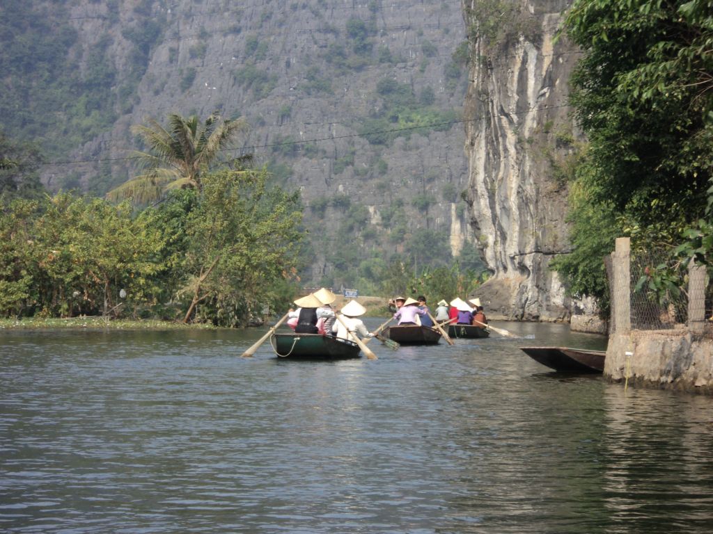 A row of boats entering the famous caves of Ninh Binh